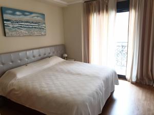 a bedroom with a white bed and a window at Apartamento Residencial Carmen in Oropesa del Mar