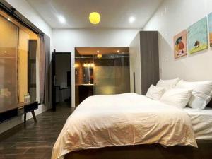 a bedroom with a large white bed and a bathroom at Tehya pool house 3 Bedrooms- My Khe Beach in Da Nang +16 photos