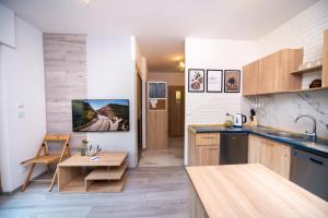 uma cozinha com armários de madeira e uma mesa de madeira em Maya's Flats & Resorts 17 - NADMOTLAWIE em Gdansk