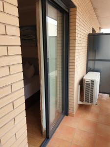 a sliding glass door on a building with a heater at Apartamento Residencial Carmen in Oropesa del Mar