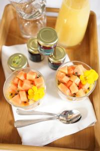 two bowls of fruit on a tray with a drink at Oceana B&B in Howrah