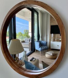 um espelho numa sala de estar com um sofá e uma cadeira em Lakeview Apartman em Alsóörs