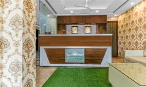 a lobby with a reception desk with a green rug at Itsy By Treebo - Royal Residency in Chandīgarh