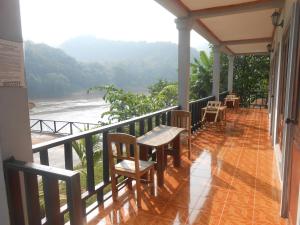 a balcony with chairs and a table and a view of the ocean at Nam Ou River Lodge in Nongkhiaw