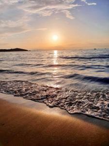uma praia com o sol nascendo sobre o oceano em Arli Hotel Hideaway Punta Ala - Adults Only em Punta Ala