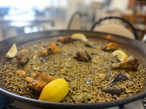 una sartén llena de comida con carne y rodajas de limón en Casa del Palmar loft, en Valencia