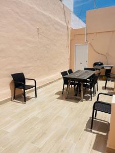 a table and chairs in a room with a wall at Casa del Palmar loft in Valencia