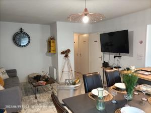 uma sala de estar com uma mesa de jantar e uma televisão em L'escale N°13 :Appartement standing dans résidence em Brest