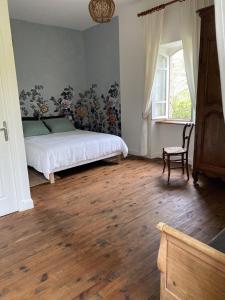 1 dormitorio con 1 cama, 1 silla y 1 ventana en Le Clos St Georges, en Entraygues-sur-Truyère
