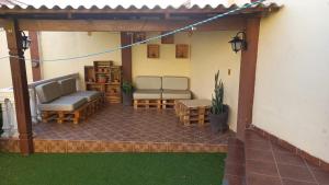 eine Terrasse mit 2 Sofas, einem Tisch und Stühlen in der Unterkunft A&A apartamento in Cochabamba