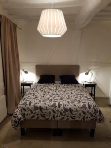 a bedroom with a bed with a black and white comforter at A 2 PAS DU PARLEMENT - 55M2 - 2 CHAMBRES in Rennes