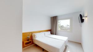 a small bedroom with a bed and a window at Villa Reymar - diseño y vistas al mar in Tossa de Mar