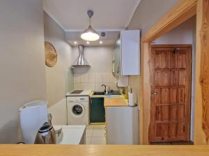 a kitchen with a refrigerator and a washer and dryer at Apartament księżycowy in Toruń