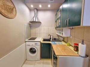 a kitchen with a washing machine and a sink at Apartament księżycowy in Toruń