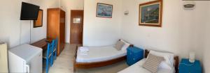 a small room with two beds and a tv at Philoxeni Akti in Kanali