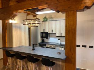 a kitchen with a large island with bar stools at El Mirador de Gredos 3 in Navaluenga
