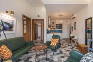 a living room with green furniture and a kitchen at Valletta Two Bedroom Apartment Close To The Sea in Valletta