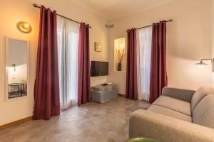 a living room with a couch and red curtains at Valletta Two Bedroom Apartment Close To The Sea in Valletta