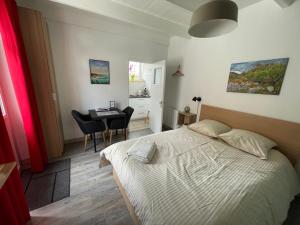 a bedroom with a bed and a desk and a table at Gites La Ville Pain in Cancale