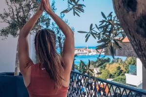 a woman standing on a balcony looking out at the ocean at Iberostar Waves Slavija in Budva