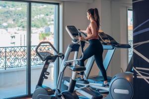 a woman riding on exercise bikes in a gym at Iberostar Waves Slavija in Budva