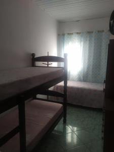 1 dormitorio con 2 literas y ventana en Quarto Triplo Solteiro, en Barueri