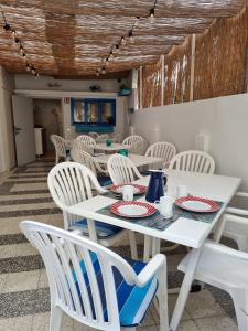 un comedor blanco con sillas blancas y una mesa en Villa Lisa - La quiete e il profumo del mare, en Grado