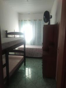 a room with a window with a bed and a bed sidx sidx sidx at Quarto Triplo Solteiro in Barueri