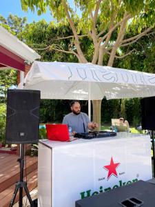 a man sitting at a table under a tent at Topazio Vibe Beach Hotel & Apartments - Adults Friendly in Albufeira