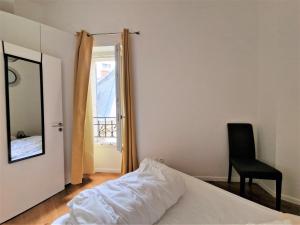 ニースにあるLe Jardin Alsace Lorraineのベッドルーム1室(ベッド1台、椅子、鏡付)
