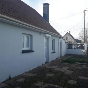 a white house with a brown roof at petite maison plain pied proche dunkerque in Boomkens
