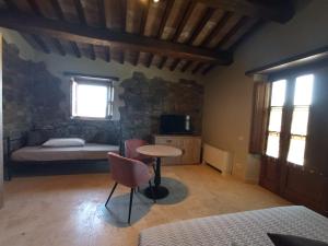 ein Schlafzimmer mit einem Bett und einem Tisch in einem Zimmer in der Unterkunft Casa al Maestro B&B in Radicofani