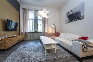 sala de estar con sofá blanco y TV en Wishlist Old Prague Residences - Haštalská, en Praga