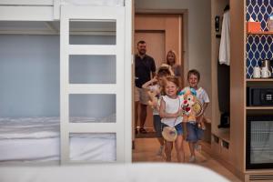 un grupo de niños parados en una habitación con dormitorio en Centara Mirage Beach Resort Dubai en Dubái