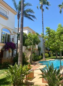 een villa met palmbomen en een zwembad bij EL PATIO - apartment LA LUBICA in Denia