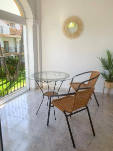 een glazen tafel en stoelen in een kamer met een balkon bij EL PATIO - apartment LA LUBICA in Denia