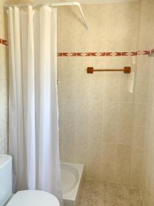 ein Bad mit einem Duschvorhang und einem WC in der Unterkunft EL PATIO - apartment LA LUBICA in Denia