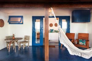 a room with a hammock in a room with a table at Pousada da Barra Caraíva in Caraíva