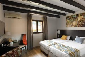 a hotel room with two beds and a window at Hotel U Ricordu & Spa in Macinaggio +43 photos