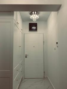 a hallway with a white door and a chandelier at Apartment Talija in Trebinje +8 photos