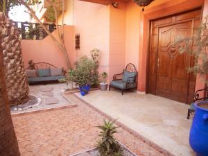 eine Eingangstür eines Hauses mit Stühlen und einer Veranda in der Unterkunft Villa Sabah in Marrakesch