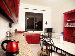 Villa Sabah في مراكش: غلاية الشاي الأحمر على منضدة في المطبخ