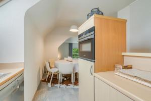 Il comprend une cuisine équipée d'une table et d'un réfrigérateur. dans l'établissement Villa Francois, à Nieuport