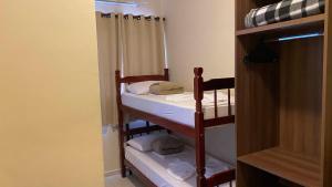 Cette chambre dispose de lits superposés avec 2 lits superposés et des serviettes. dans l'établissement Pousada Santa Inês, à Cachoeira Paulista