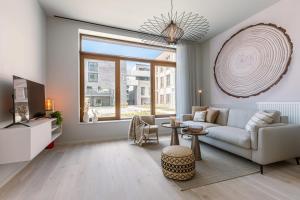 a living room with a couch and a large window at Luxurious flat "de zilte zeezoen" close to the sea in Ostend