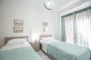 a bedroom with two beds and a window at Jiji Riji Zante Apt in Zakynthos