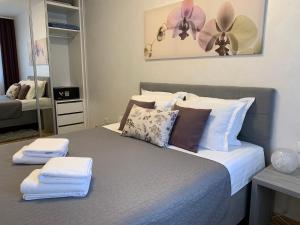 a bedroom with a bed with towels on it at Kraljev Park sa parking mestom in Novi Sad