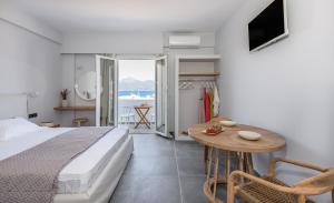 a bedroom with a bed and a table and a television at Hotel Ippocampos Studios in Adamantas