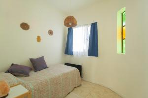 un dormitorio con una cama y una ventana en Crisálida Puerto Madryn, en Puerto Madryn