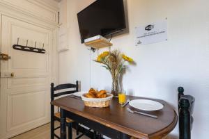uma mesa de jantar com uma tigela de pão em Le Studio d'Isa em Seigy
